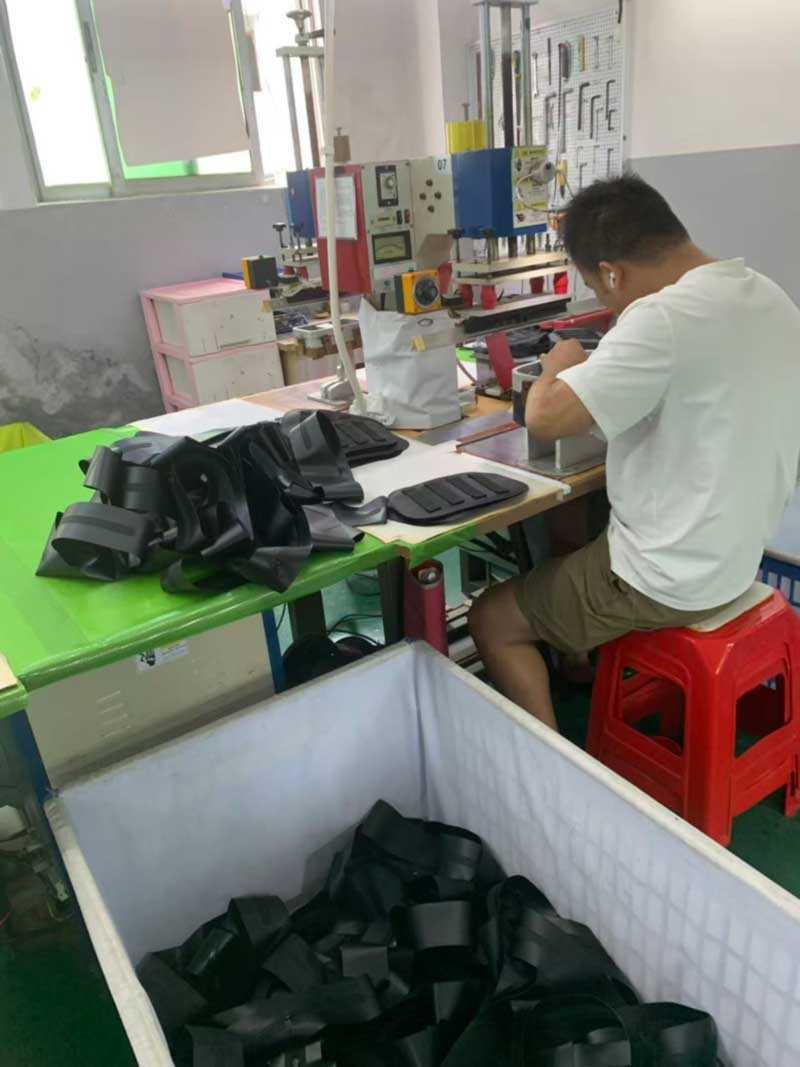 Operator welding channel patterns into padded backpack back panels